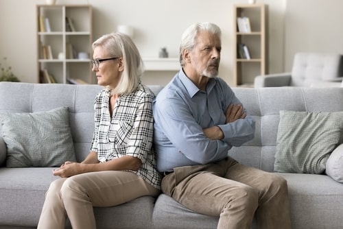 Older couple sitting on a couch no looking at each other
